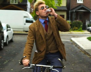 Pat Mills as David Gold rides his bike while drinking alcohol in this still from his movie Guidance