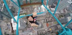 We Kill Death, dare devil, Mustang Wanted hangs from a crane atop 60-story building in downtown Toronto. - photo: Lu Chau / courtesy of Let it Play