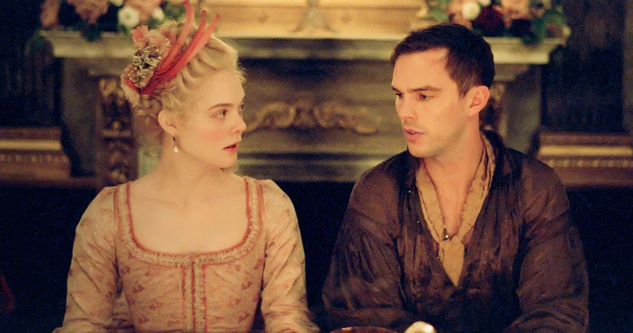 Actress Elle Fanning as Catherine the empress of Russia sitting next to actor Nicholas Hoult as Peter the emperor in a comedic take on Russian history in HULU series, The Great