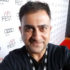 Publisher, writer, Henrick Vartanian wearing a black V-neck shirt posing for a profile photo on the red carpet at the AFI Film Fest in Los Angeles.