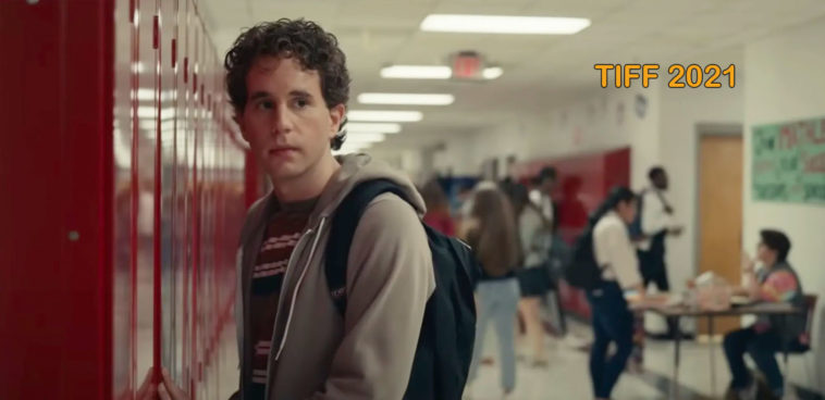 Standing by a row of school lockers. curly haired actor Ben Platt as high school student, Evan Hansen in Dear Evan Hansen movie