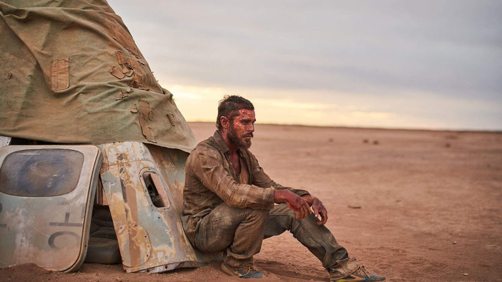 Zac Efron plays a desperate stranger, sunburnt and patiently waiting in the desert, in GOLD movie (2022)
