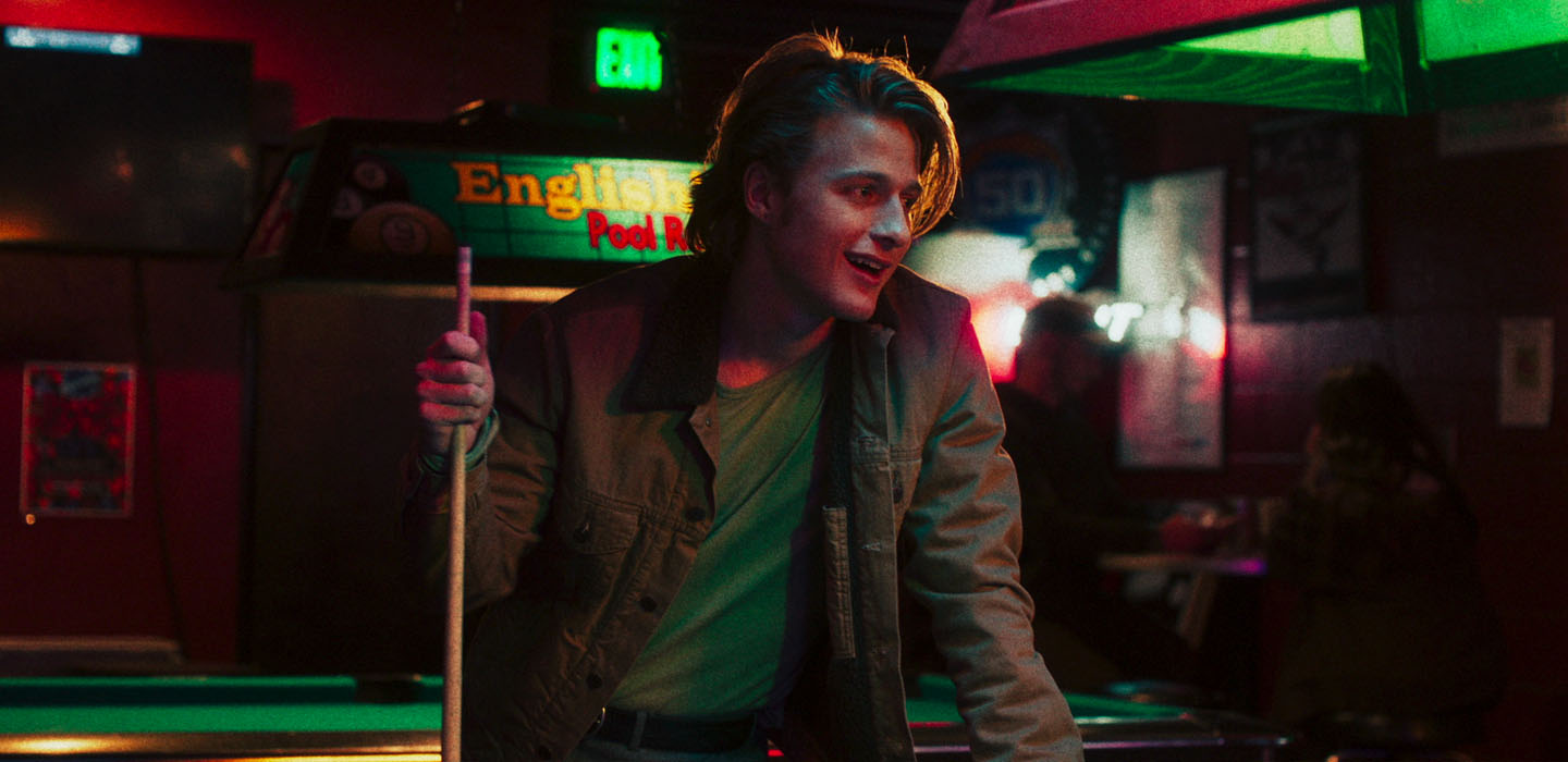 actor Pedro Correa holds onto a cue stick as he stands by a pool table in a still photo from MY DEAD DAD movie.